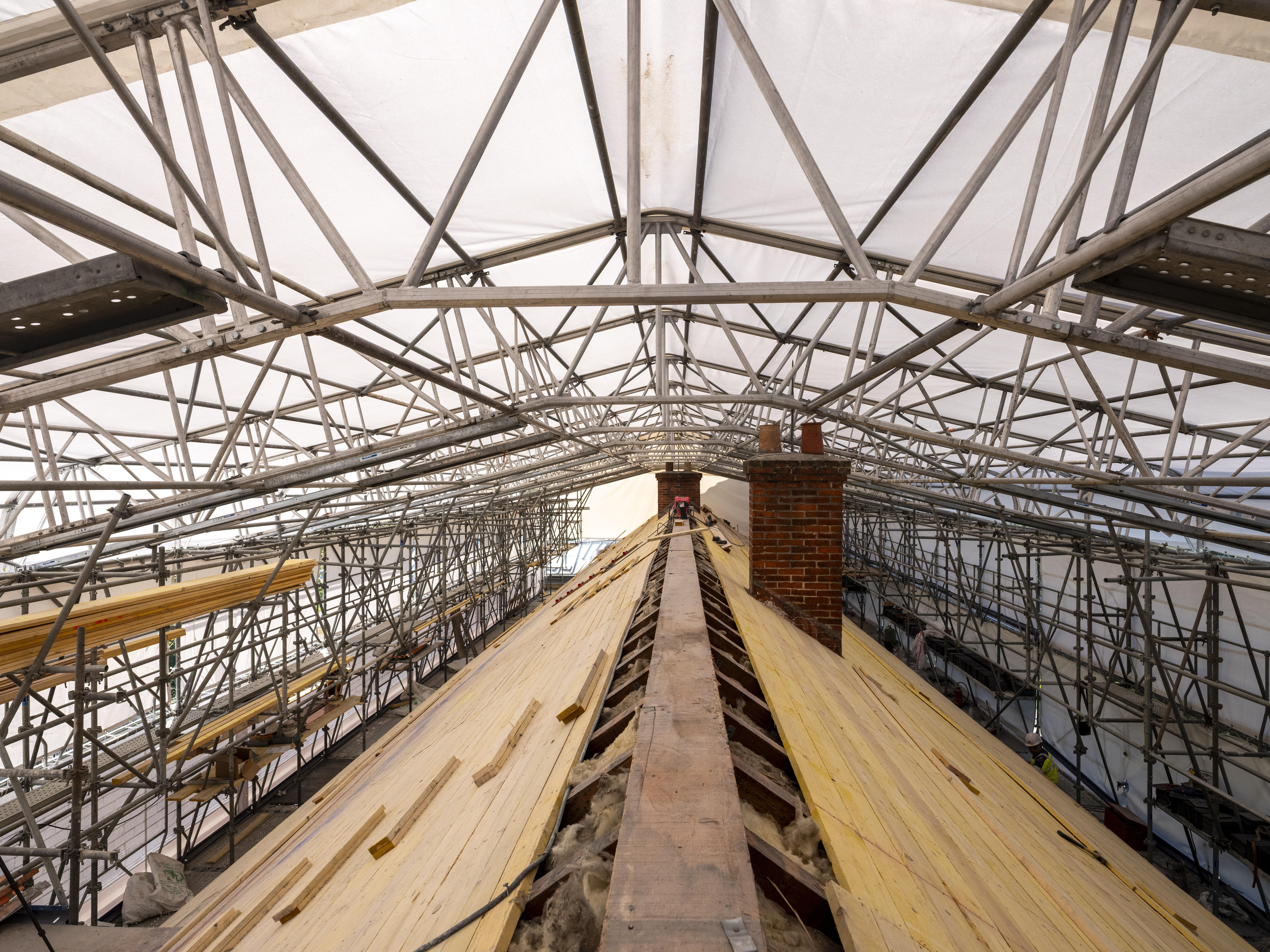 Toiture du château de Malmaison en restauration, avec charpente et cheminée apparentes