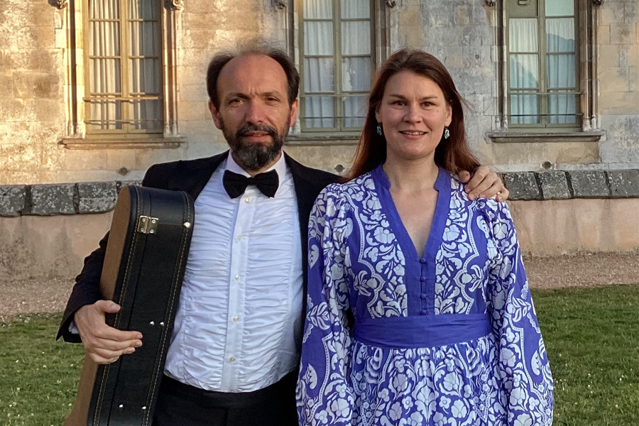 Deux artistes côte à côte, l'un tenant un étui de guitare