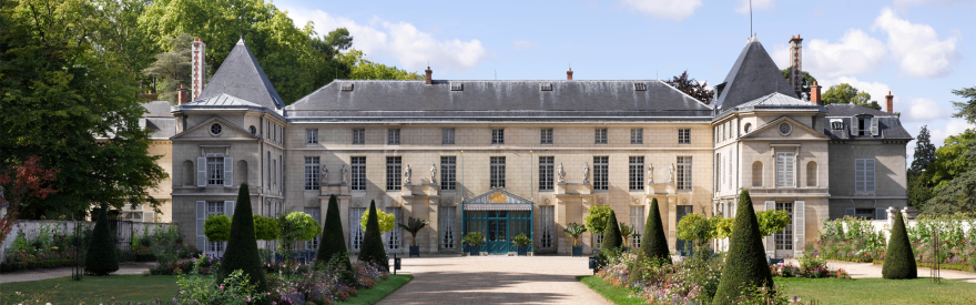 Vue extérieure du château de Malmaison depuis l'allée centrale, bordée de parterres de fleurs
