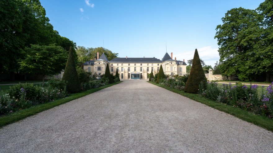 Vue au loin de la façade principale du château de Malmaison depuis l'entrée de la grille d'honneur