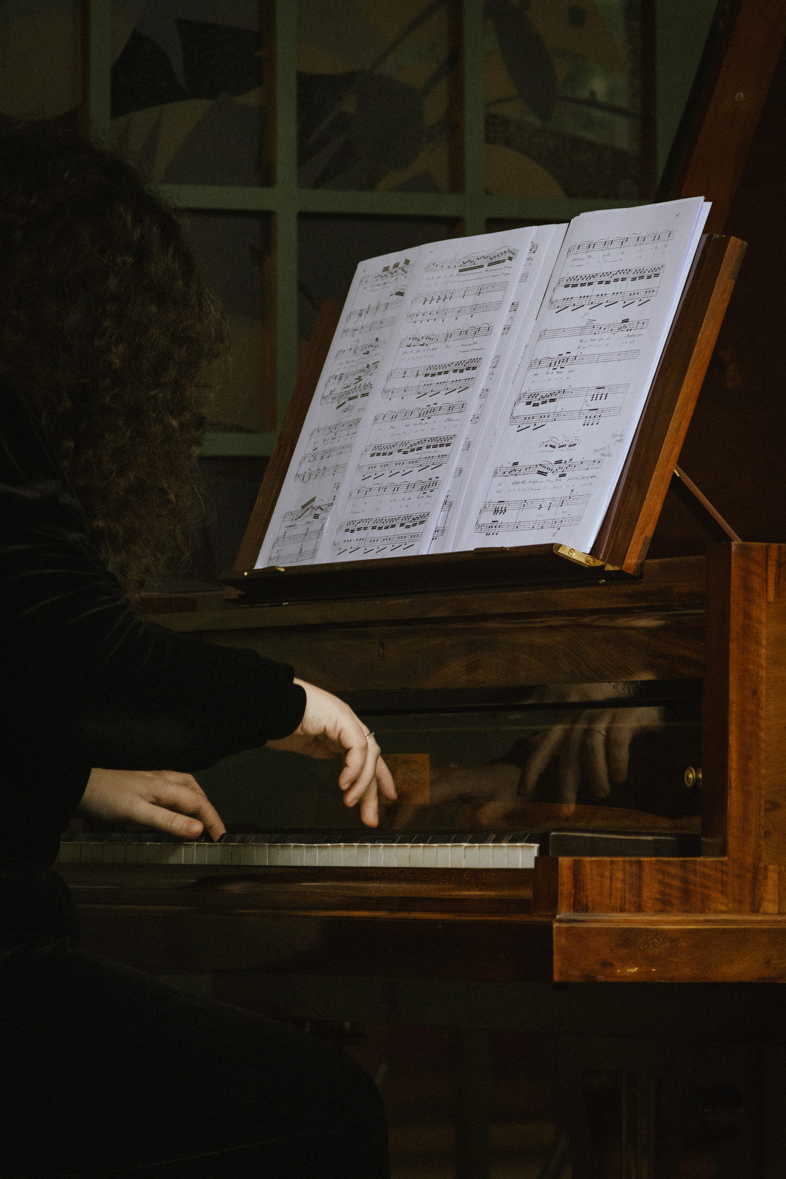 Gros plan sur les mains d’un pianiste jouant sur un piano d’époque