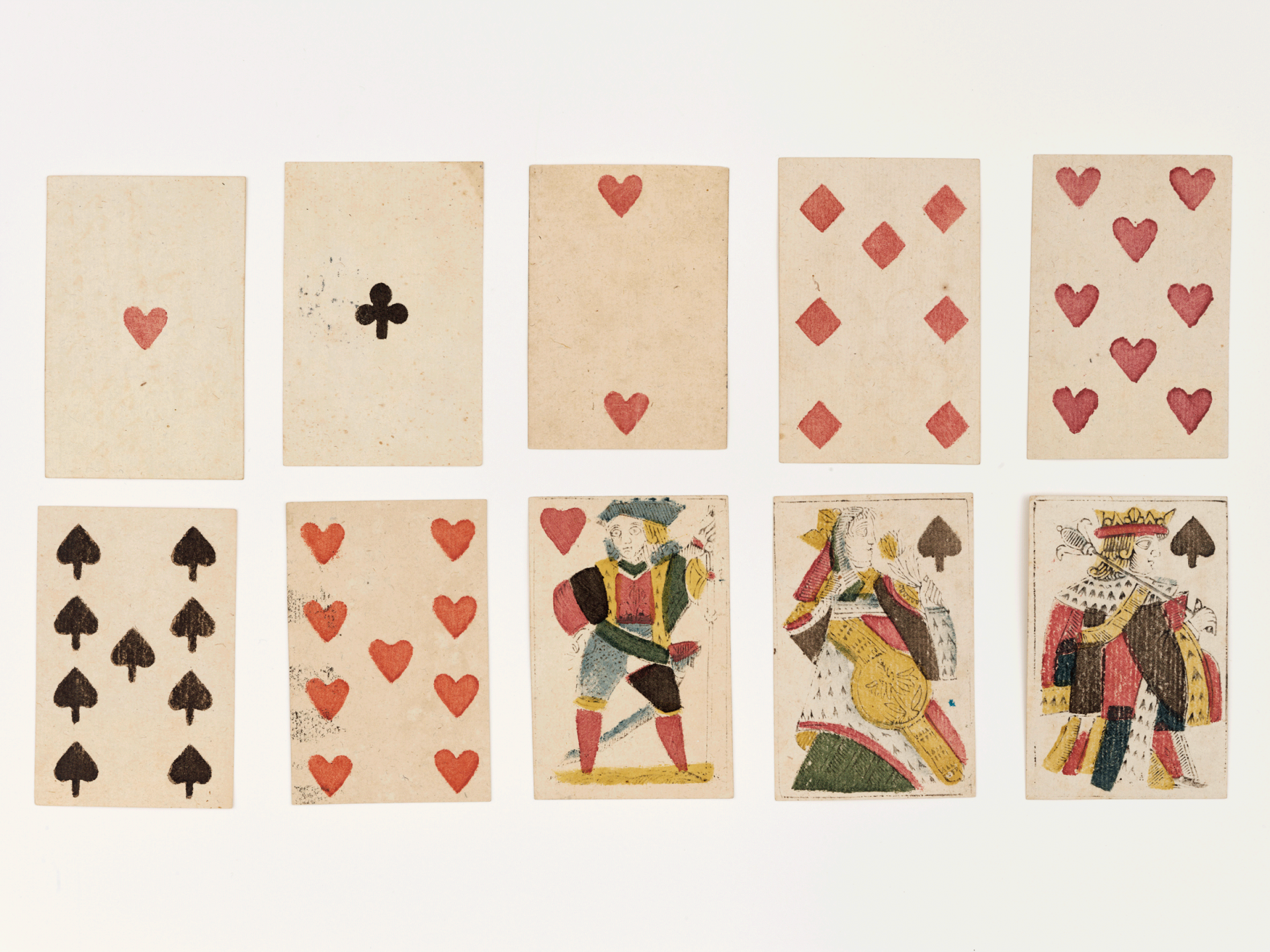 Jeu de cartes ancien avec des trèfles, des carreaux, des cœurs et des piques.