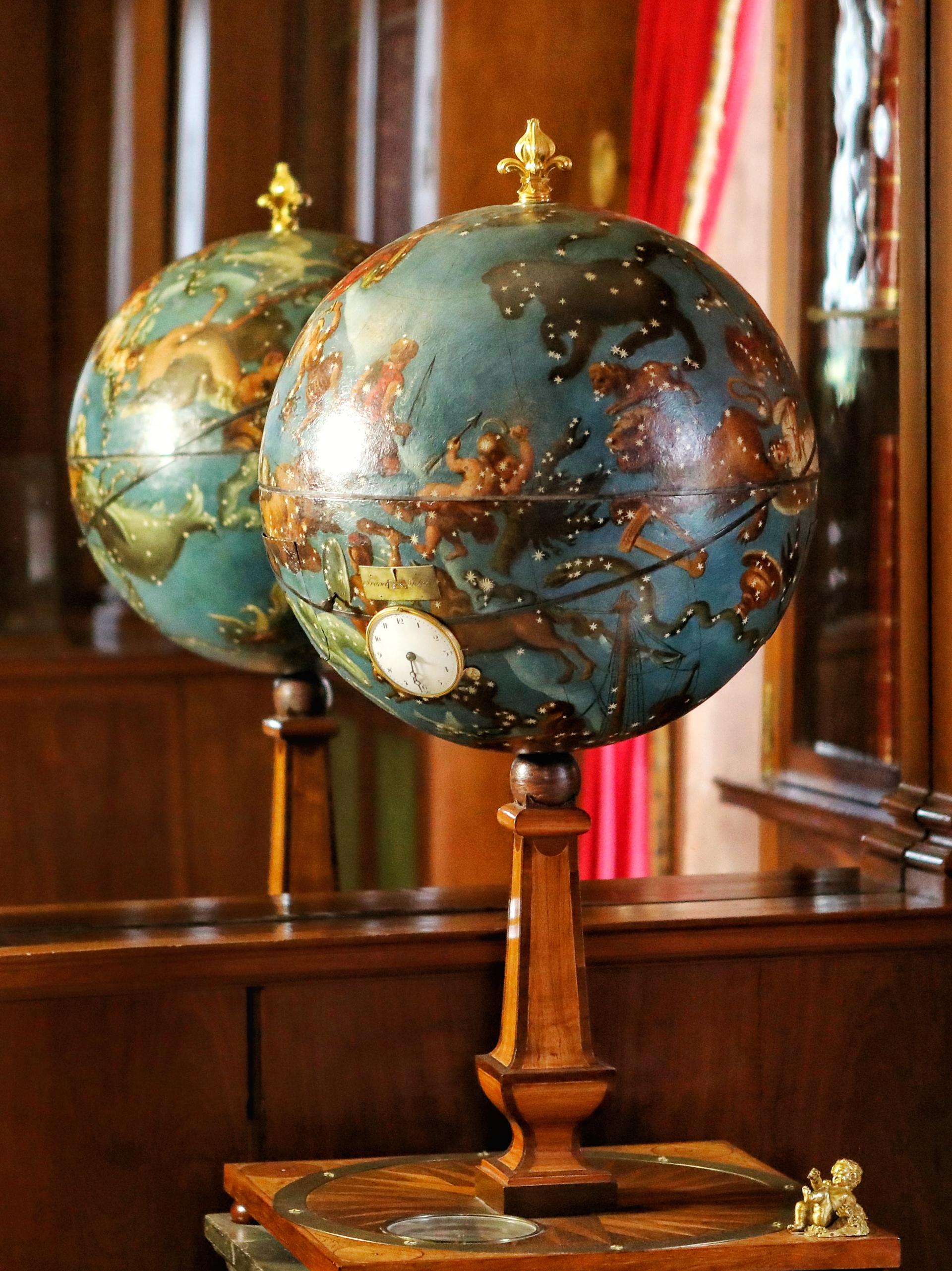 Globe présenté fermé, posé sur un piètement décoré.